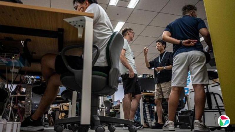 东京都厅内一群作随意短袖衣裤打扮的公务员在交谈(14/7/2026)