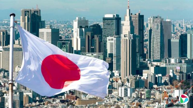 一面日本国旗在东京天际线前飘扬