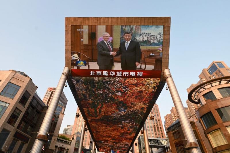 北京一家购物中心外的屏幕上正在播放微软联合创始人比尔·盖茨去年6月会见习近平主席的新闻画面。