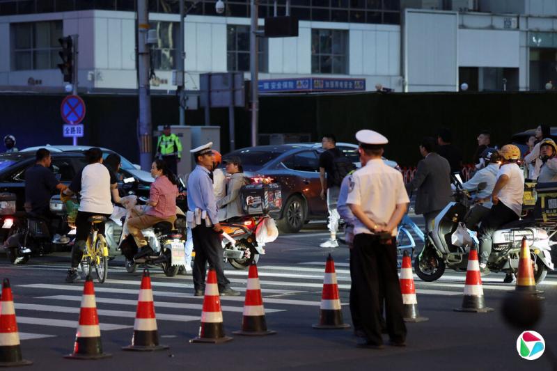 警察在靠近中信大厦的十字路口巡视,大厦外墙高层可见受损。
